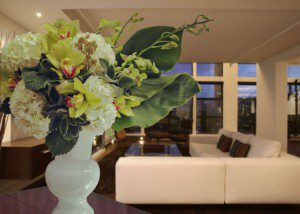Residential floral design: Succulent blooms, white hydrangea, green dendrobium, calla lily leaves, green cymbidium orchids.