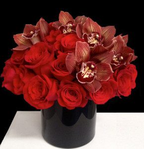 Midnight in Paris: red roses and orchids in a sleek black vessel.
