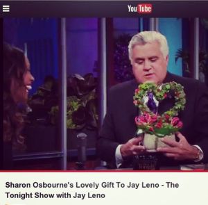 Jay Leno accepts a floral heart arrangement by La Petite Gardenia from Sharon Osbourne.