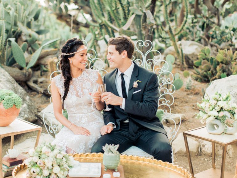 Newlyweds toast in a desert oasis accented by wedding florals by La Petite Gardenia.