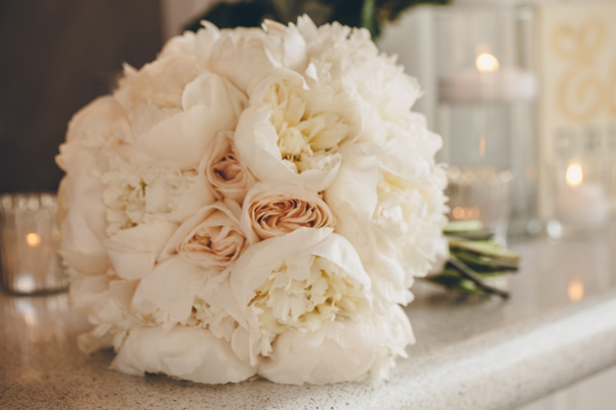 A blush bridal bouquet lies on a table